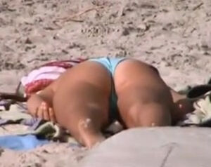 Female in bikini drains twat on the beach